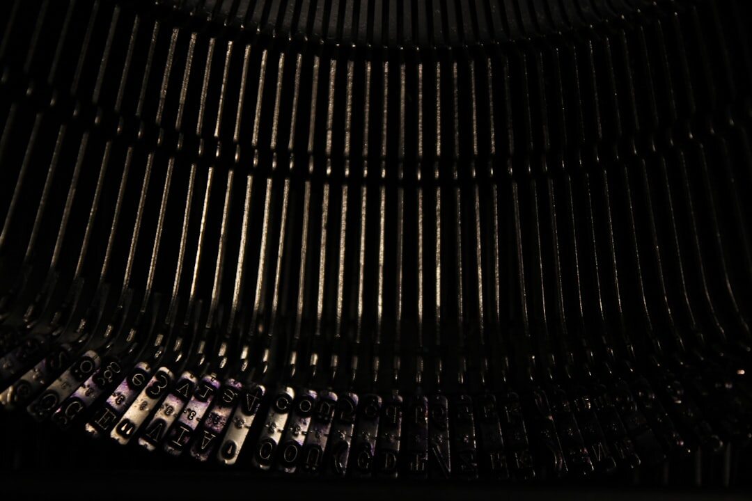 Close-up of a vintage typewriter with a half-typed page under dim lamp light